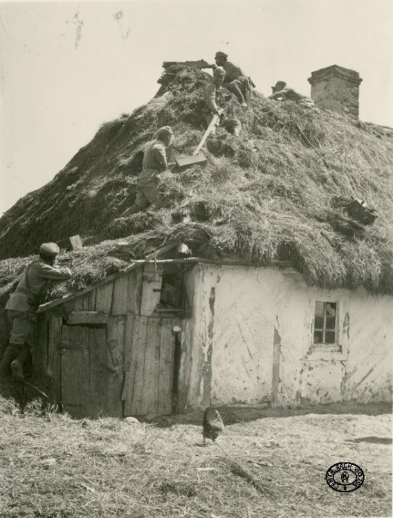 Stanowisko ciężkiego karabinu maszynowego 8 mm Schwarzlose wz. 1907/12 na dachu budynku mieszkalnego. Żołnierze z I Brygady Legionów Polskich wciągają skrzynki amunicyjne. Tur Dolny, rejon walk nad Nidą. 10.05.1915 r. Źródło: CAW.jpg