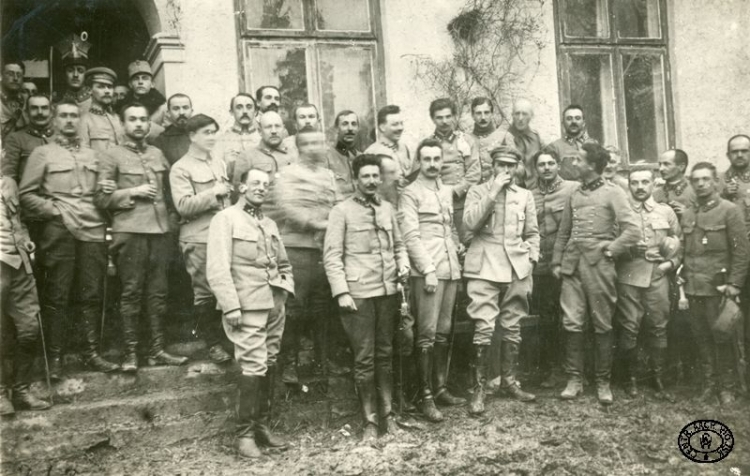 Imieniny Komendanta Piłsudskiego. Stoją: w I rz. od L – M. Śniadowski, J. Sawicki, K. Sosnkowski, J. Piłsudski, W. Wieczorkiewicz, S. Skotnicki, M. Trojanowski, S. Tessaro, w II rzędzie od P –S. Rouppert, M. Dąbkowski, I. Daszyński. Na schodach od L: J. Stachiewicz, T. Kasprzycki, o. K. Lenczowski, J. Bandrowski, W. Biernacki, A. Litwinowicz, A. Fleszar, 4. od P W. Prażmowski, w drzwiach S. Burhardt, G. Dreszer, poniżej T. Furgalski. Dwór Juliana Zubrzyskiego, Grudzyny, pozycje nad Nidą. 19.3.1915. CAW