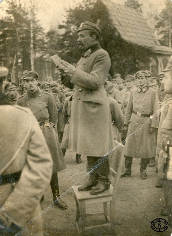 Odczytanie aktu 5 listopada przez ppłk. Leona Berbeckiego w obozie legionowym w Baranowiczach. Z prawej por. Aleksander Łuczyński ps. „Narbut”. 5.11.1916 r. Źródło: CAW