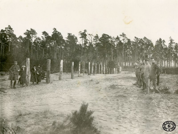 Odwiedziny rodzin w obozie internowanych oficerów legionowych. Z prawej strony: ppor. Ludwik Skrzyński „Kmicic” (drugi od lewej), por. Kazimierz Stamirowski, N.N., por. Jan Lewandowski, rtm. Wacław Graba-Łęcki (Rettinger). Beniaminów. 1917 r. Źródło: CAW