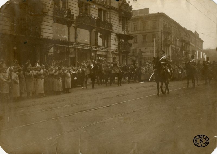 Wkroczenie oddziałów legionowych do Warszawy. Defilada 2 Pułku Ułanów Legionów Polskich na Krakowskim Przedmieściu. Defiladę przyjmują oficerowie niemieccy (z lewej). 1.12.1916 r. Źródło: CAW