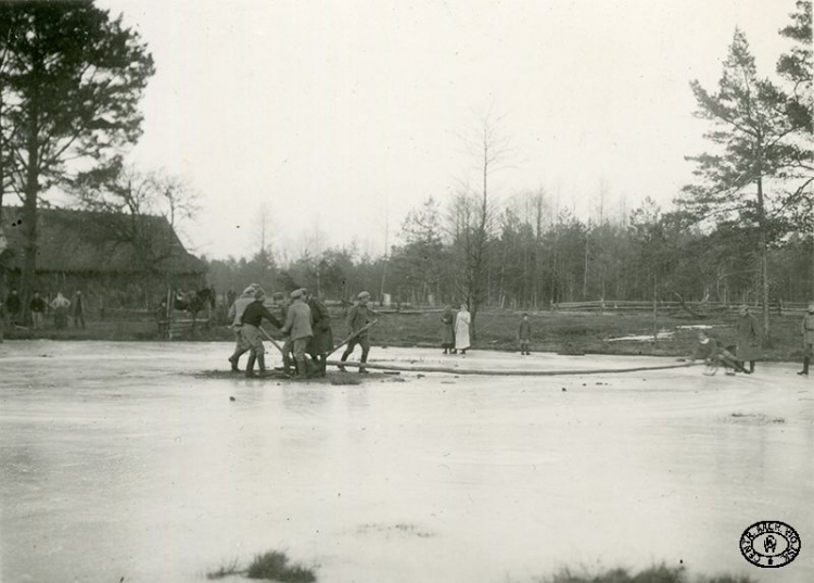 Żołnierze I Brygady Legionów Polskich z miejscowymi dziewczętami bawią się na zamarzniętym jeziorku. Leśniewka, Wołyń. Kwiecień 1916 r. Źródło: CAW