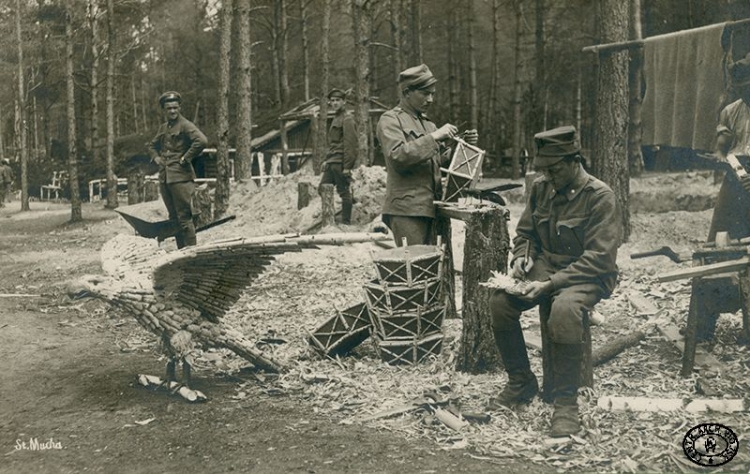 Żołnierze 4. Pułku Piechoty Legionów Polskich konstruują ozdoby z drewna (m.in. orła i muchę) na ziemianki w Rojowym Osiedlu. Zaplecze pozycji nad Styrem, Wołyń. Wiosna 1916 r. Źródło: CAW