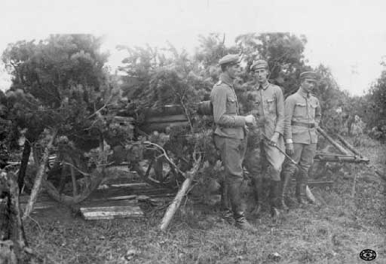 Oficerowie 2 baterii artylerii Legionów Polskich stoją przy działach na pozycji pod Sitowiczami. W środku stoi ppor. Józef Beck. Widoczna zamaskowana armata polowa 76,5 mm wz. 1905. Pozycje nad Stochodem, Wołyń. Sierpień, 1916 r.