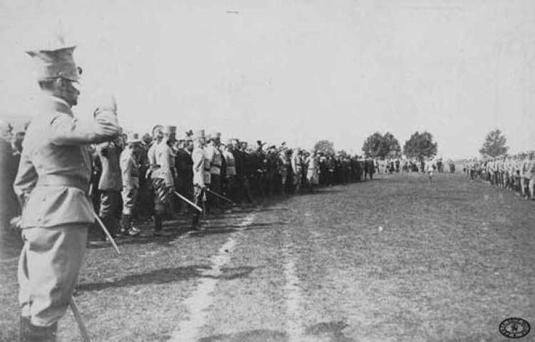 Gen. Rajmund Baczyński, dowódca Legionu Zachodniego, przyjmuje defiladę 2 Pułku Piechoty Legionów Polskich po przysiędze na Błoniach krakowskich. W grupie osobistości stoją: szef Departamentu Wojskowego NKN Władysław Sikorski, prezydent Krakowa Juliusz Leo, prezes Naczelnego Komitetu Narodowego Władysław Leopold Jaworski, Mieczysław Trojanowski. Kraków. 4.09.1914 r.