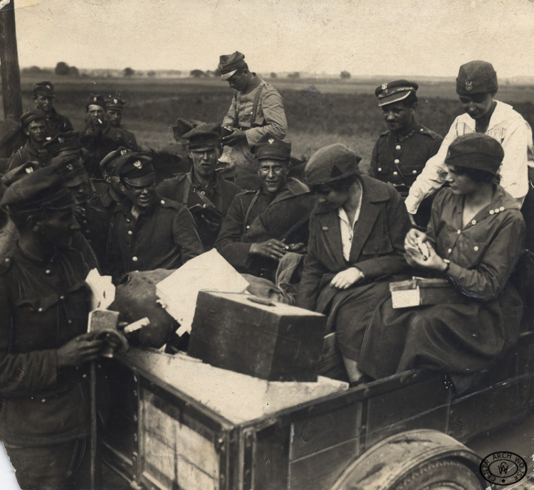 Przedstawiciele YMCA rozdają posiłek i papierosy na szosie radzymińskiej, 1920. Źródło: CAW