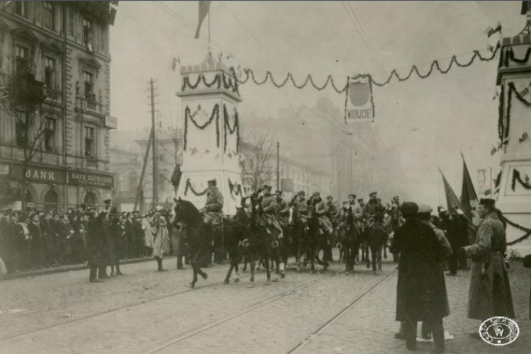 Wkroczenie oddziałów legionowych do Warszawy. Wojska przejeżdżaja przez bramę triumfalną w Al. Jerozolimskich. Źródło: CAW