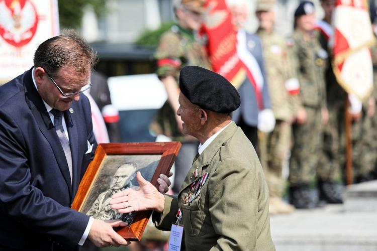 Weteran Stanisław Kawałek (P) wręcza zdjęcie marszałka Józefa Piłsudskiego szefowi Urzędu do Spraw Kombatantów i Osób Represjonowanych Janowi Józefowi Kasprzykowi - uroczystości przed Pomnikiem Czynu Zbrojnego Polonii Amerykańskiej w ramach trwającego w Warszawie Światowego Zjazdu Weteranów Walk o Niepodległość RP. Fot. PAP/L. Szymański