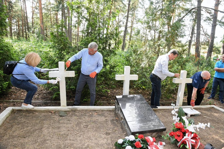 Marszałek Senatu Stanisław Karczewski (C) z delegacją odnawiają nagrobne krzyże na cmentarzu legionistów w Wołczecku. Fot. PAP/R. Pietruszka