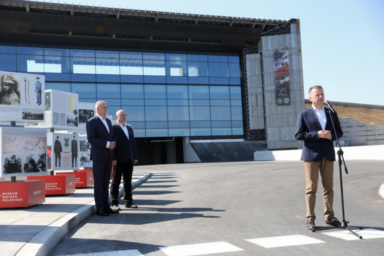 Minister obrony narodowej Mariusz Błaszczak (P), starosta wołomiński Adam Lubiak (L) oraz dyrektor Muzeum Wojska Polskiego Paweł Żurkowski (2L) podczas otwarcia wystawy plenerowej towarzyszącego piknikowi wojskowemu przed Muzeum Bitwy Warszawskiej w Ossowie. 13.08.2023. Fot. PAP/R. Guz