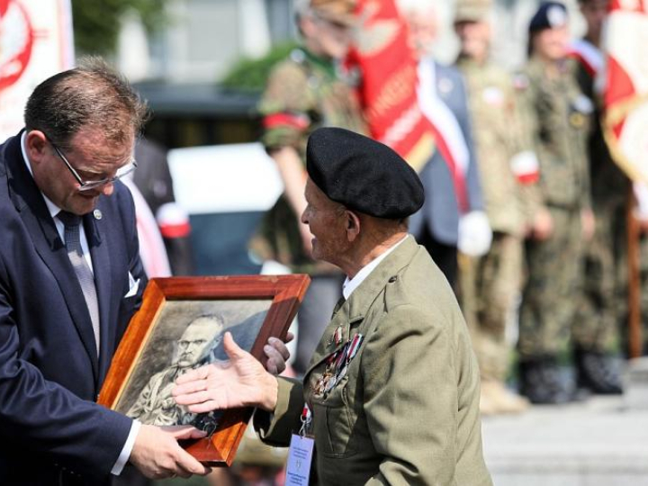 Weteran Stanisław Kawałek (P) wręcza zdjęcie marszałka Józefa Piłsudskiego szefowi Urzędu do Spraw Kombatantów i Osób Represjonowanych Janowi Józefowi Kasprzykowi - uroczystości przed Pomnikiem Czynu Zbrojnego Polonii Amerykańskiej w ramach trwającego w Warszawie Światowego Zjazdu Weteranów Walk o Niepodległość RP. Fot. PAP/L. Szymański