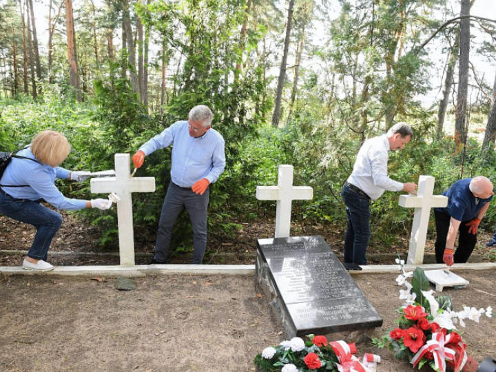 Marszałek Senatu Stanisław Karczewski (C) z delegacją odnawiają nagrobne krzyże na cmentarzu legionistów w Wołczecku. Fot. PAP/R. Pietruszka