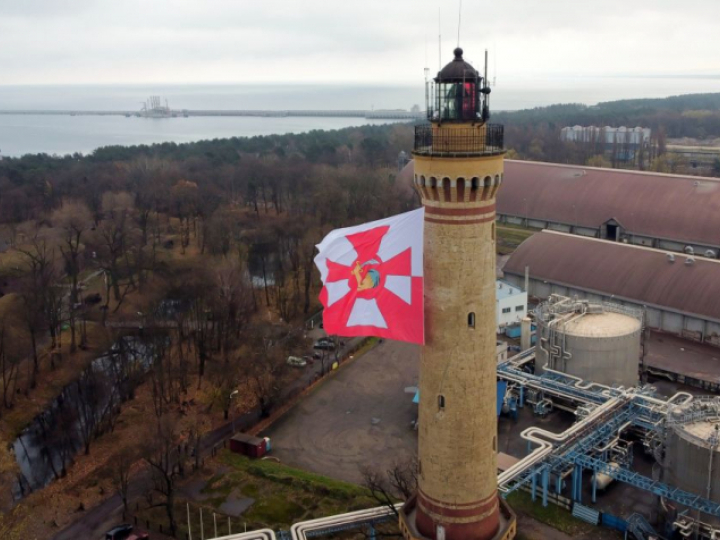 Historyczny proporzec Marynarki Wojennej na latarni morskiej w Świnoujściu w 103. rocznicę utworzenia MW. Fot. PAP/M. Bielecki